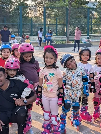 Look at this team of happy skaters! We believe in creating a supportive group environment where every child feels like a champion. Here, our coach celebrates with a group of young skaters after a successful class, all geared up and proud of their progress.