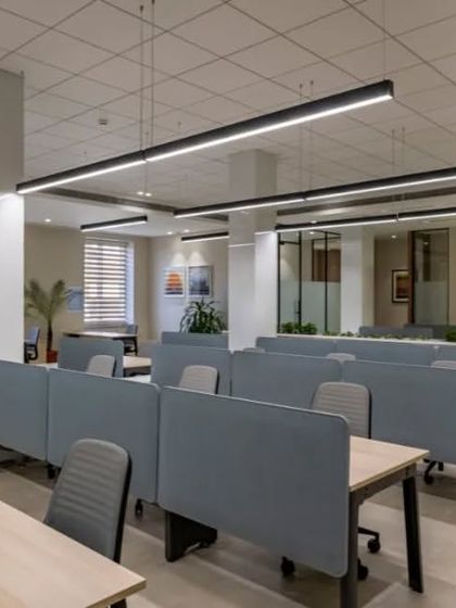 This view shows the flow from the open work area to private offices in the background. The consistent design language ensures the entire floor feels like a single, cohesive space.