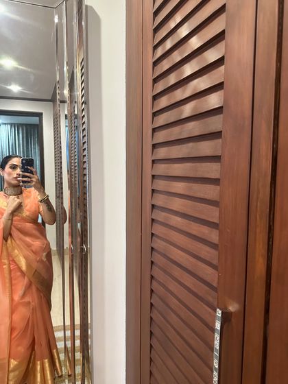 A mirror selfie in a peach organza saree I designed. It’s light, airy, and perfect for daytime summer festivities.