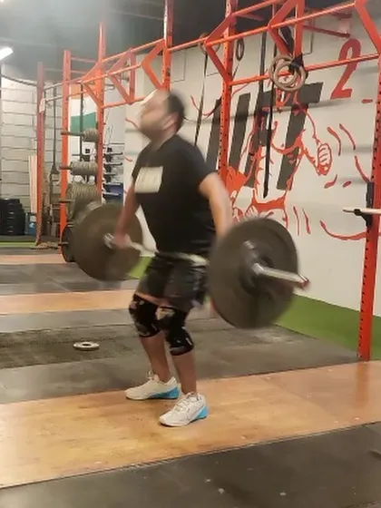 This client is in the middle of a hang snatch, a variation that increases time under tension and builds significant back strength. The motion blur captures the explosive nature of the lift.