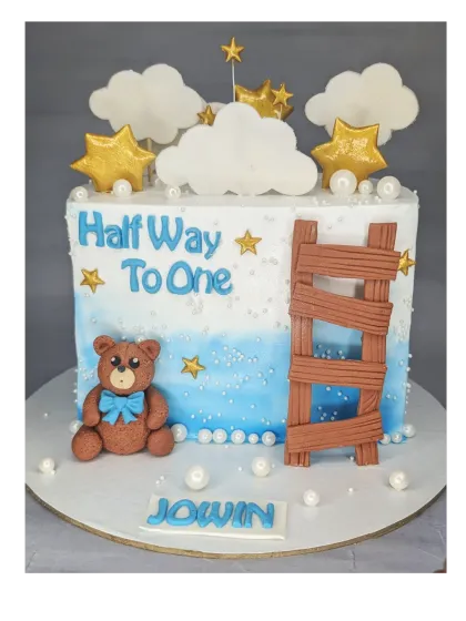 A square-shaped half birthday cake with an Oreo cookie flavor. This design features a teddy bear, a ladder, and stars, celebrating the climb to the one-year mark.