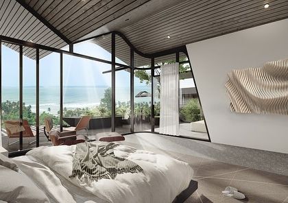 This bedroom in our Dona Paula project features panoramic windows to capture the sea view. The room's design is intentionally minimal, with a dynamic, sloping ceiling that reflects the building's overall architectural form.