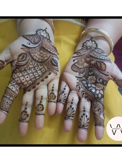 A pair of hands with matching Arabic designs.