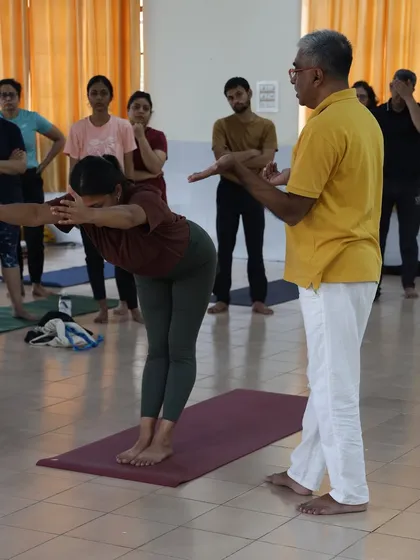 A teacher explains the alignment for Ardha Uttanasana, the half forward bend, during a Surya Namaskar workshop. Understanding the details is key to a safe practice.