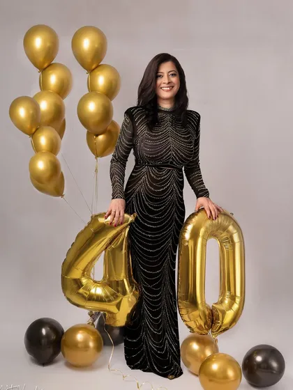 Forty and fabulous. This elegant portrait with a black beaded gown and gold balloons is a sophisticated way to celebrate a milestone birthday. She is absolutely glowing with confidence.