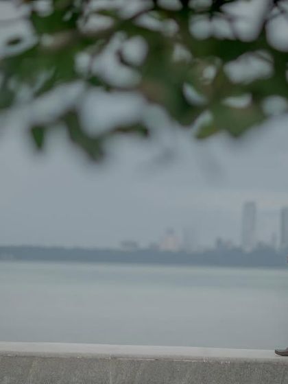 A candid shot capturing a quiet moment at Marine Drive, with the iconic Mumbai skyline in the background. This tells a story of love in the city.