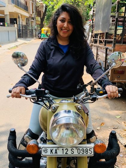 A graduate's confident smile as she sits on her Royal Enfield. She is ready for any adventure that comes her way.