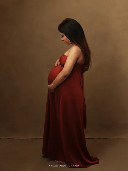 A side profile of the mother-to-be, her hands cradling her belly. This simple, elegant pose is a timeless way to document the beauty of pregnancy.