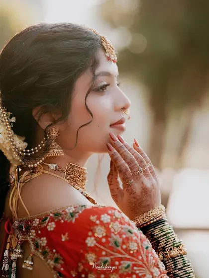 A side profile of the bride, showcasing her elegant hairstyle, jewelry, and the delicate features of her face. A truly classic and graceful portrait.