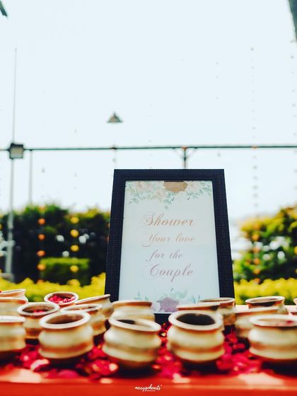 "Shower your love for the couple." A sweet little detail from a Haldi ceremony, with pots of petals ready for guests.