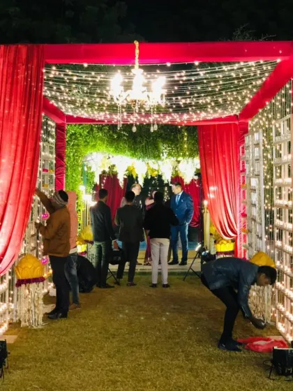 A bright and festive entrance with red drapes and a canopy of fairy lights, showing my team adding the final touches.