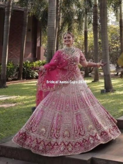 A full-length shot of the bride, twirling in her magnificent pink lehenga. Her mehendi is a key part of her complete bridal look, adding to her grace and elegance.