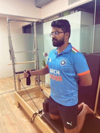 This client is performing a rotator cuff rehabilitation exercise on the Pilates reformer. The machine's spring resistance provides a safe and effective way to strengthen the delicate muscles of the shoulder.