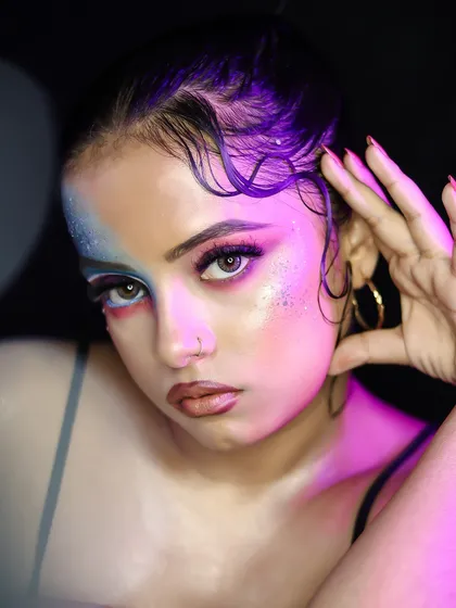 A close-up of the graphic makeup, showing the blend of colors and the glossy texture on the skin and hair.