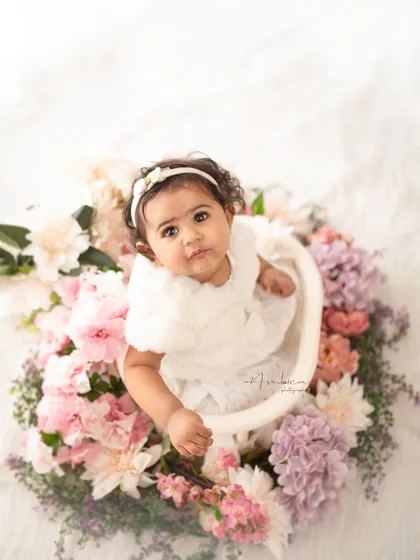 An angelic sitter session portrait, with the baby nestled in a wreath of fresh flowers. These sessions, ideal for babies between 8-10 months, are all about capturing that sweet, curious stage in a beautiful, light-filled setting.