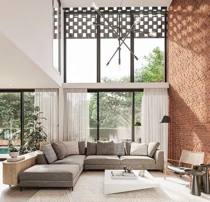 This living room from the Kolgaon Masterplan showcases our approach to material honesty. A double-height brick wall serves as the central feature, complemented by large glazing that floods the space with natural light and connects the home to the surrounding landscape.