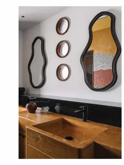 A detail from the 'Aria' master bathroom, where the walls themselves are the art. The reflection in the custom-shaped mirrors reveals the Van Gogh-inspired china mosaic, while the Jaisalmer stone basin adds another layer of natural, earthy texture.