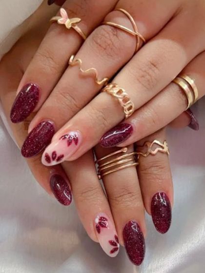 A lovely design with maroon glitter nails and accent nails featuring hand-painted maroon flowers.