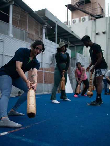 A female participant practices her form with a Mudgar under the watchful eye of a coach during an L1 session. We focus on precise technique to ensure our future instructors can teach safely and effectively.