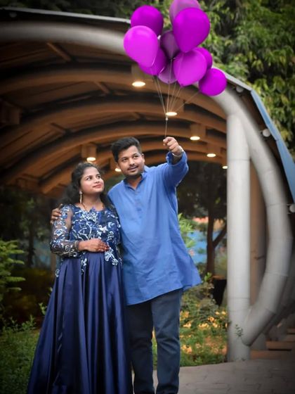 This navy blue satin gown with floral embroidery is a sophisticated choice for a pre-wedding or maternity shoot.