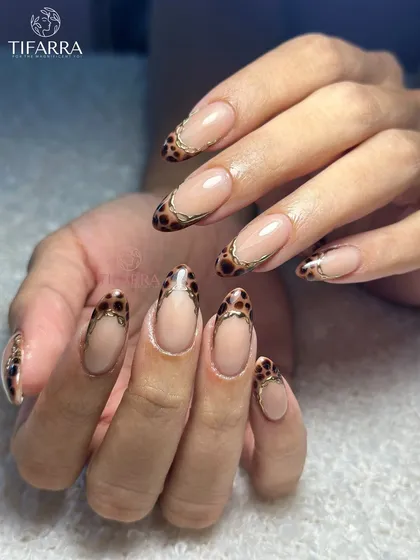 Who said fierce can’t be feminine? A modern take on French tips with a hand-painted leopard print design, outlined in gold chrome.