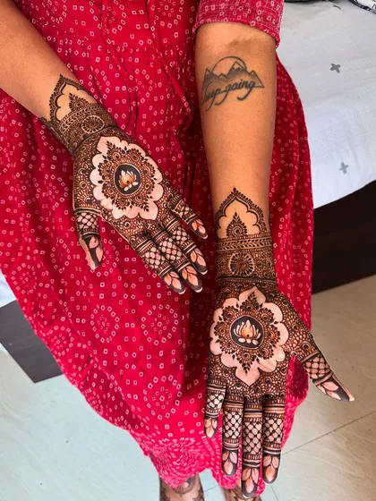 This design blends modern minimalism with traditional symbolism. The central lotus motif, created with negative space, makes a bold statement, while the delicate finger and wrist work adds a touch of classic elegance.