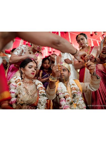 A key moment in a South Indian wedding where the 'Thali' (sacred thread) is tied, symbolizing the union.