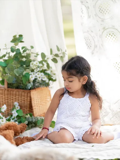 A solo portrait of the little girl from the family picnic session. She looks so sweet and thoughtful sitting on the blanket.
