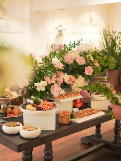 A glimpse into one of our bespoke catering events. This stunning grazing table, adorned with fresh flowers, features an array of canapés, cheeses, and delicious bites, demonstrating our ability to elevate any gathering into a memorable gourmet experience.