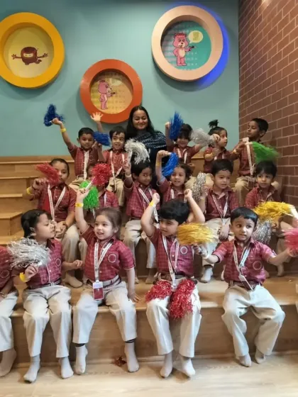All smiles and ready for fun! Students from Somerville International School pose with their teacher and colorful pom-poms during their exciting field trip.