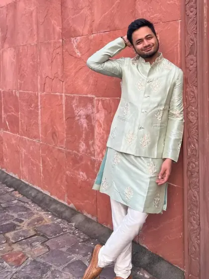 A relaxed shot of a client in a pista green kurta and embroidered jacket. The simple elegance of this outfit makes it suitable for a destination wedding event.