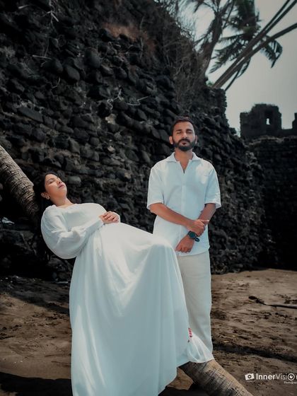 An artistic pose by a palm tree on the beach, with ancient fort walls in the background. This shot combines natural beauty with a touch of historical grandeur.