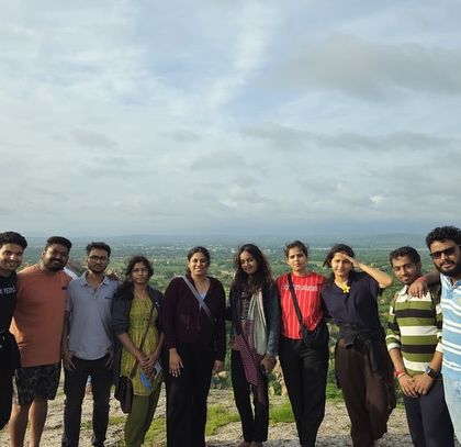 The group enjoying the sunset view from Hemakuta Hill in Hampi, with a panoramic view of the ruins below.