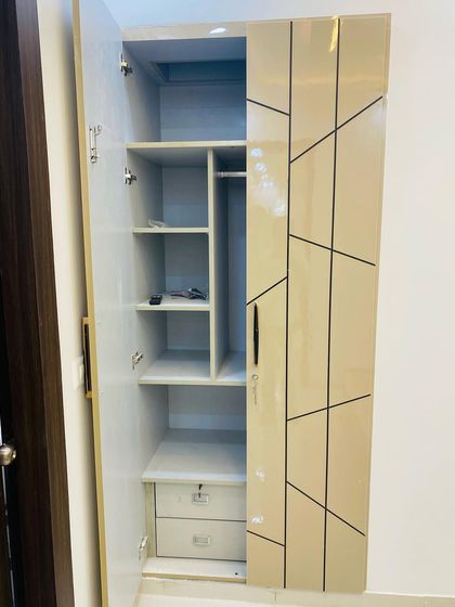The inside of a two-door wardrobe, showing a compact yet efficient layout with shelves, hanging space, and internal drawers.