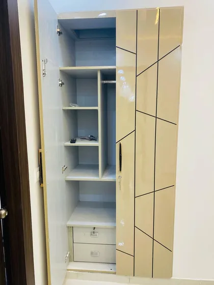 The inside of a two-door wardrobe, showing a compact yet efficient layout with shelves, hanging space, and internal drawers.
