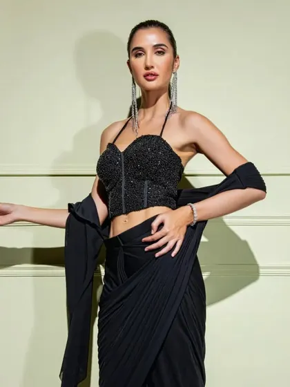 A closer look at the black drape saree with a structured halter-neck corset, perfect for a bold and modern statement.