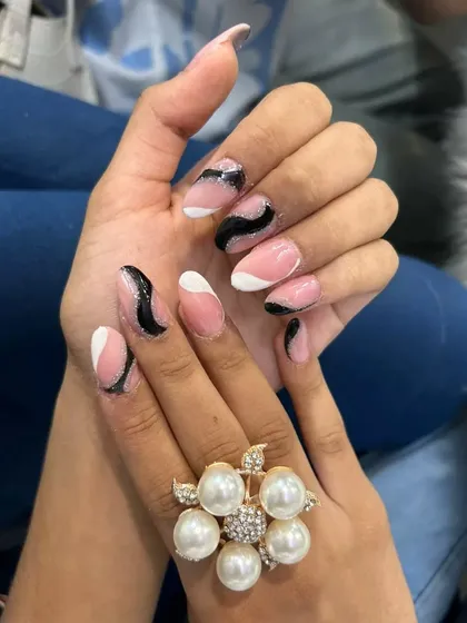 For a modern and chic look, I designed this abstract nail art using a soft pink base with bold black and white waves, accented with a hint of black glitter. This style is done on durable acrylic extensions, perfect for making a statement.