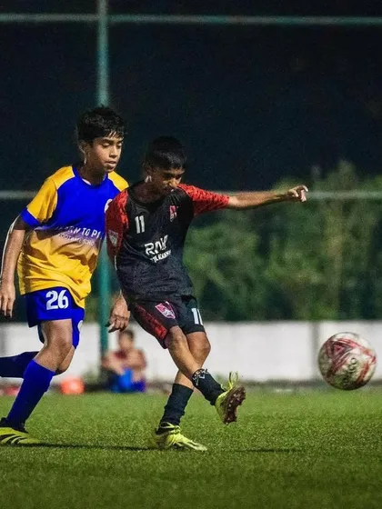 An intense one-on-one battle for the ball during the U13 semi-final match.