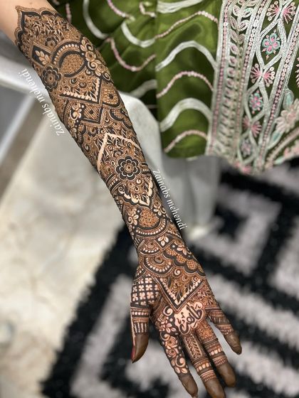 A full view of Madeeha's bridal arm, with her name elegantly written in Urdu on the palm.