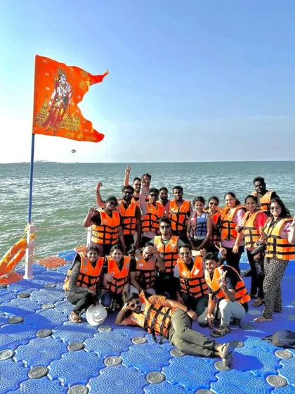 Our group on a floating platform in the sea, with a flag flying high, celebrating a long weekend trip.