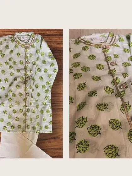 This handcrafted cotton kurta set features a playful green leaf motif. The intricate gold piping and statement buttons add a hint of festive flair.