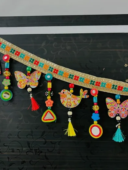 A slightly different angle of the 'Bageecha Toran', showing the playful arrangement of its hand-stitched elements.