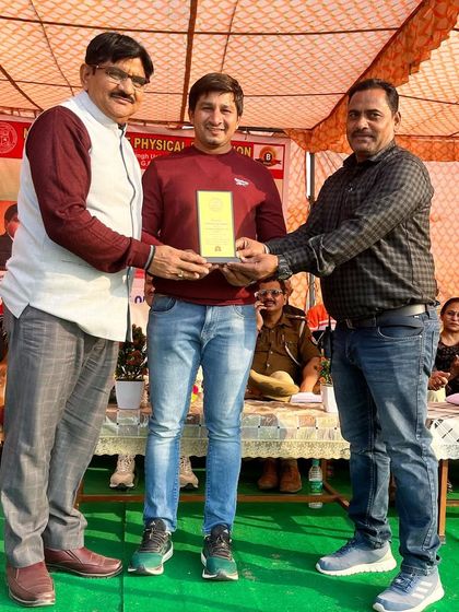 Receiving an award at the Noida College of Physical Education. It is an honor to be recognized for our contribution to athletics.