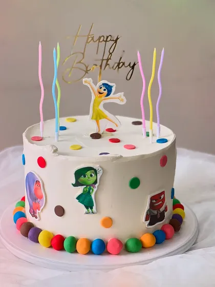 An "Inside Out" themed birthday cake made with my Belgian Chocolate flavor. It's decorated with colorful polka dots, character cutouts, and rainbow candles.