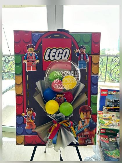 "Everything is awesome" with this Lego-themed 40th birthday setup. A custom-printed backdrop and a colorful balloon bouquet bring the fun and creativity of Lego to life for a playful milestone celebration.