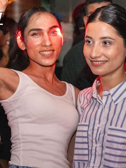 Two friends enjoying the music under the bright lights of the club.