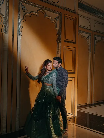 A romantic portrait of the couple during their Sangeet. The dramatic lighting and their elegant attire create a moody and glamorous shot.