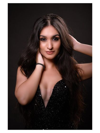 A glamorous studio portrait in a sparkling black dress. The model's pose is elegant and sophisticated.
