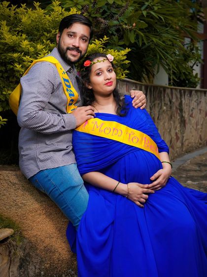 A fun and celebratory photo of a couple wearing "Mom to be" and "Dad to be" sashes. This relaxed outdoor shot perfectly captures their shared excitement.