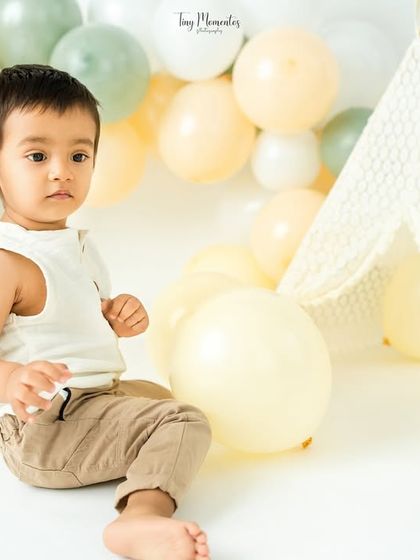 A quiet moment of observation in the boho-themed setup, complete with a lace teepee and soft, earthy-toned balloons.